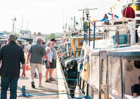 People walking along the Midland harbour looking at boats
