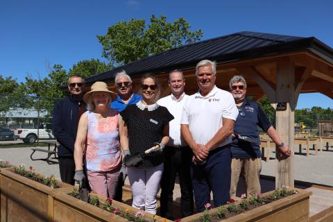 Members of Tiny Council, MPP Assistant Leslie Stroud, Accessibility Advisory Committee members posing in front of gazebo with flower box in front