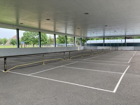 A view of the Perkinsfield Pavillion with 3 pickleball nets set up across the concrete pad.