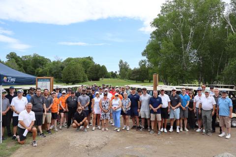 A group shot of all golfers in the 2026 Mayor's Charity Golf Tournament posing in front of golf carts