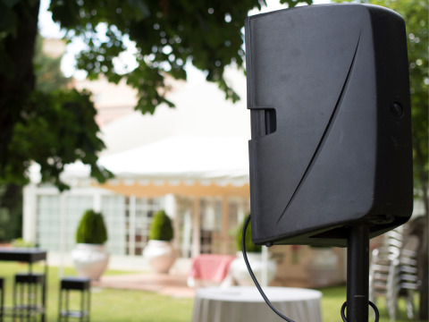 Large black speaker with outdoor furniture in the background